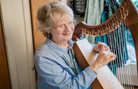 Therapeutic harp practitioner Margaret Stephens playing the harp